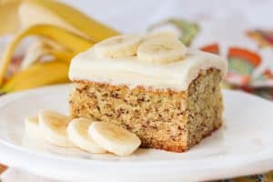 A slice of cake on a plate with bananas.