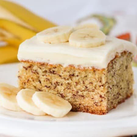 A slice of cake on a plate with bananas.