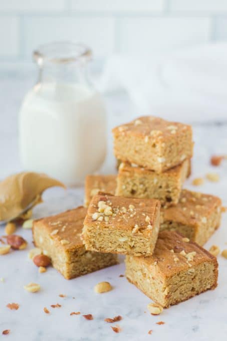 A glass of milk and some pb brownies.