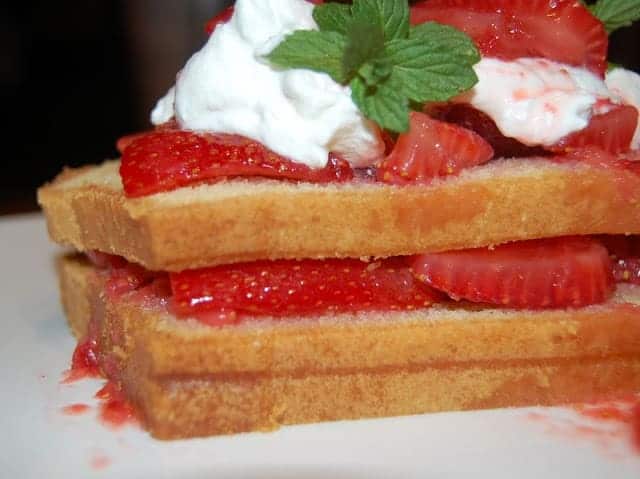 Layered Pound Cake topped with whipped cream and strawberries