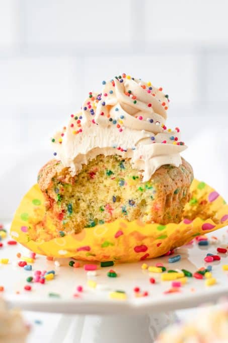 A bite taken out of a Birthday Funfetti Cupcakes
