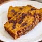 Two slices of Chocolate Chunk Pumpkin Bread with cinnamon sugar topping on a plate.