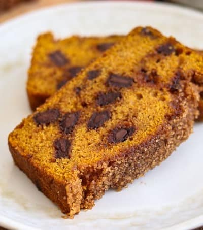 Two slices of Chocolate Chunk Pumpkin Bread with cinnamon sugar topping on a plate.