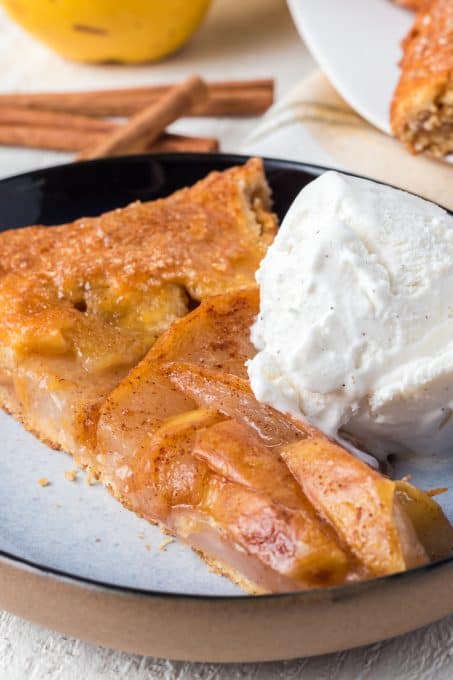 A scoop of vanilla ice cream on a pear galette.