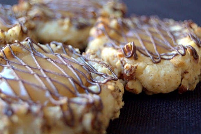 A delicious shortbread cookie rolled in pecans with a caramel center and drizzled with chocolate.