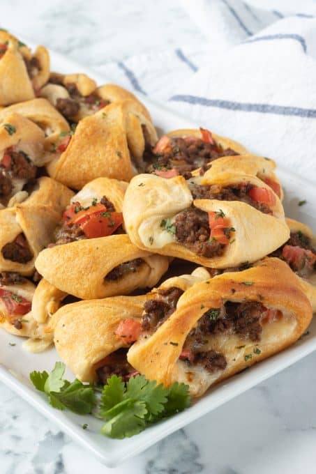 Taco seasoned meat with tomatoes and cheese in crescent dough.