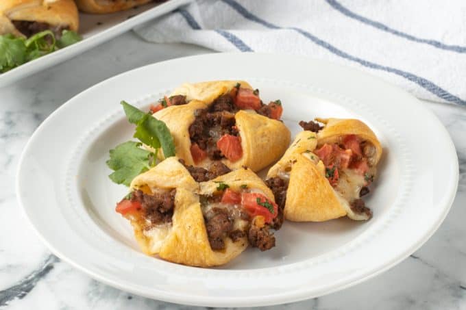 Taco seasoned meat with tomatoes and cheese in crescent dough.