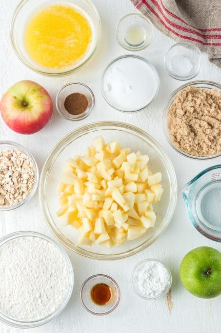 Ingredients to make an apple dessert with cinnamon and oats.