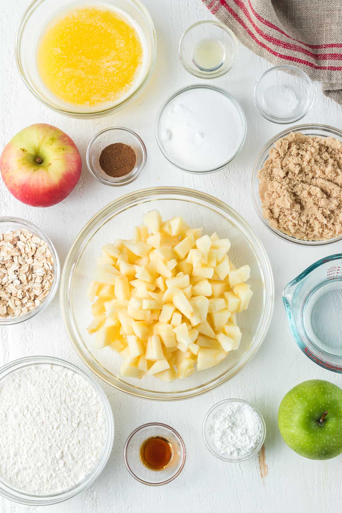 Ingredients to make an apple dessert with cinnamon and oats.