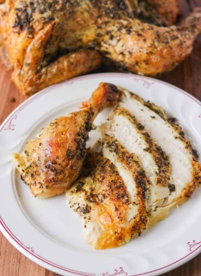 A drumstick and slices of chicken coated in herbs and lemon.