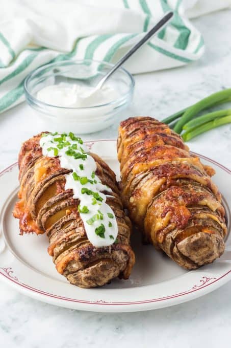 Sour cream and chives topping a potato with Parmesan cheese.