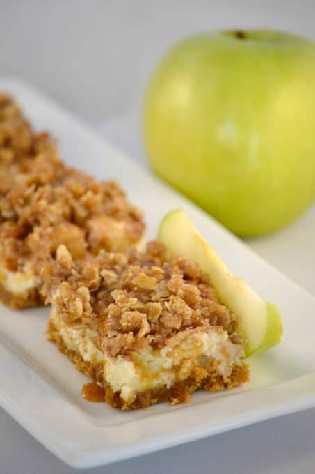 Caramel Apple Cheesecake Bars - cheesecake over a graham cracker crust covered with cinnamon apples, a streusel topping and drizzled with sweet caramel.