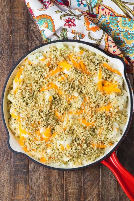 Cauliflower topped with cheeses and bread crumbs before being baked.