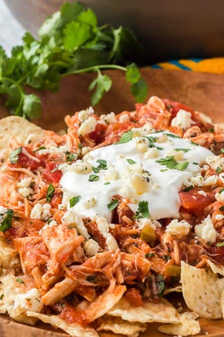 Chicken and salsa topped with sour cream on tortilla chips.