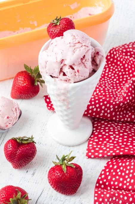 A cup of ice cream with strawberries