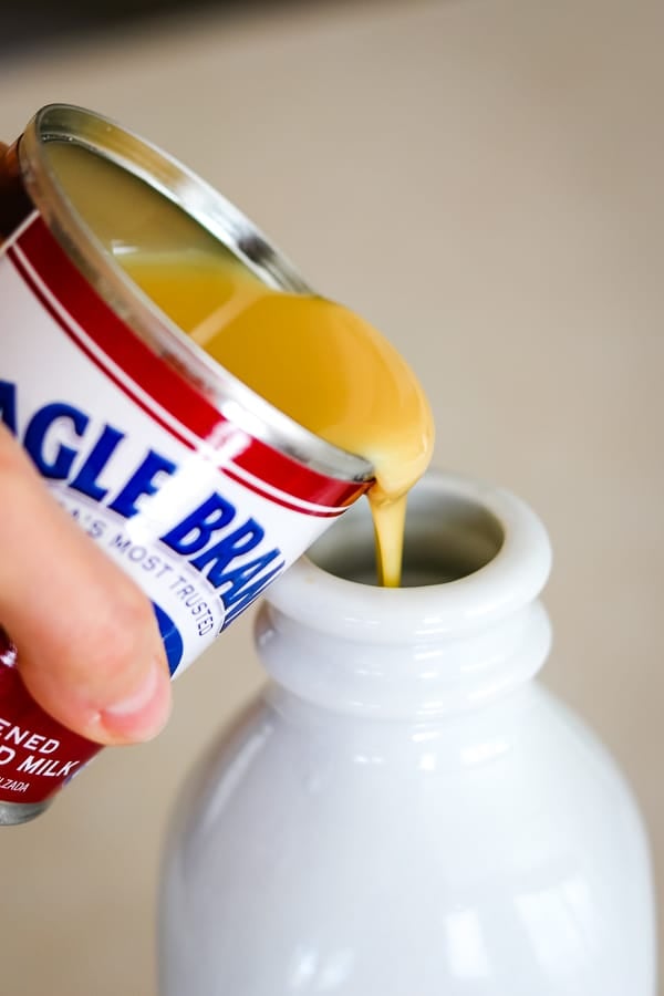 Pouring sweetened condensed milk into the Homemade French Vanilla Coffee Creamer.