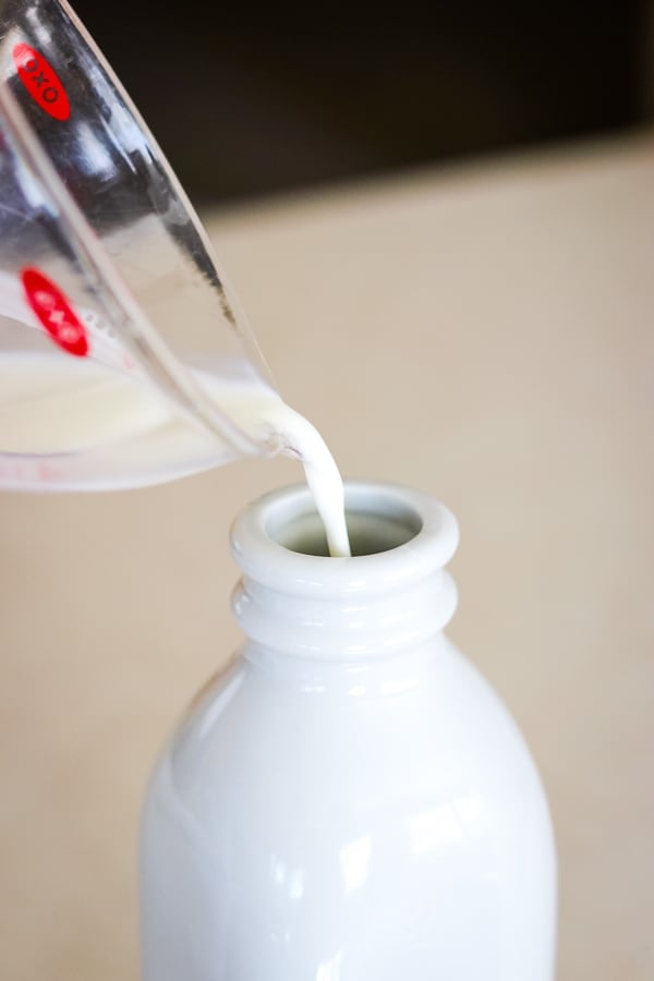 Pouring milk into the Homemade French Vanilla Coffee Creamer.