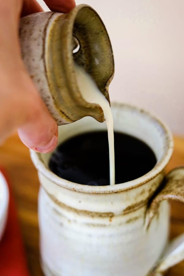 Pouring the Homemade French Vanilla Coffee Creamer into coffee.