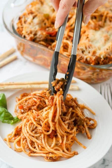 Setting a plate of spaghetti baked in the oven.