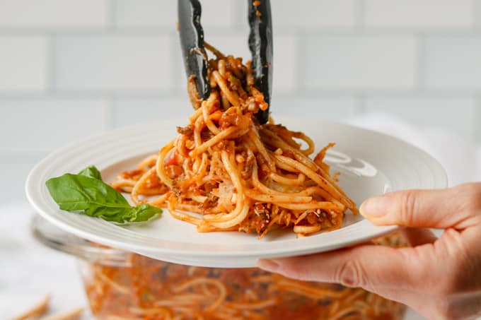 Setting a plate of spaghetti and meat sauce baked in the oven.