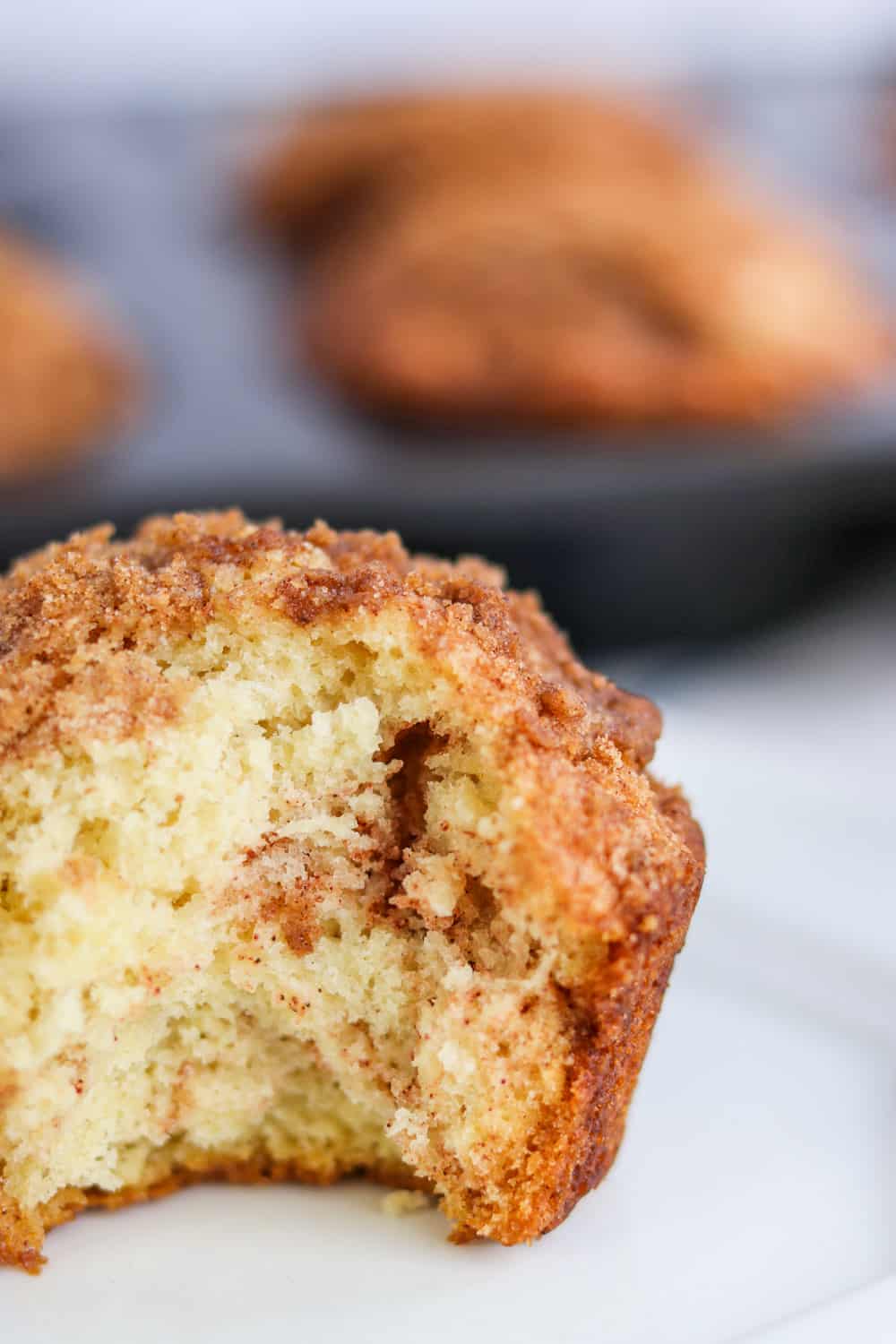 A bite taken out of a Cinnamon Streusel Muffin. 