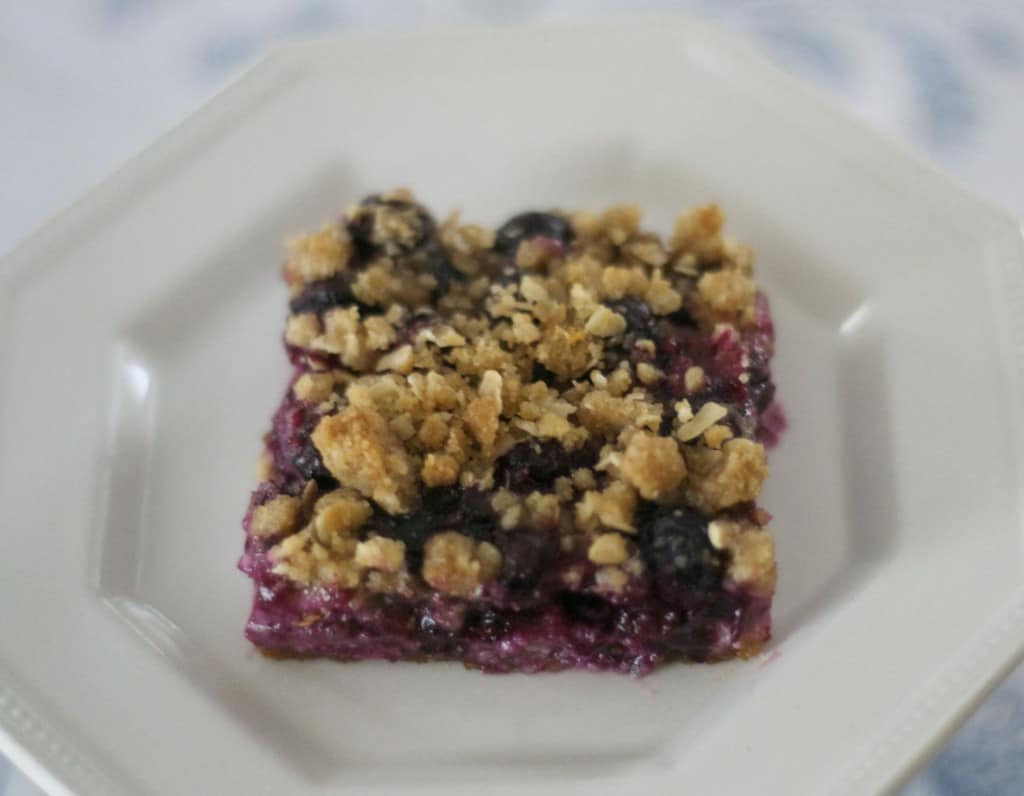 Blueberry Lemon Cheesecake Bars - lemony cheesecake bars covered in blueberries and a lemon streusel topping.