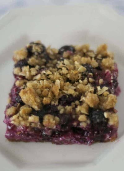 Blueberry Lemon Cheesecake Bars - lemony cheesecake bars covered in blueberries and a lemon streusel topping.