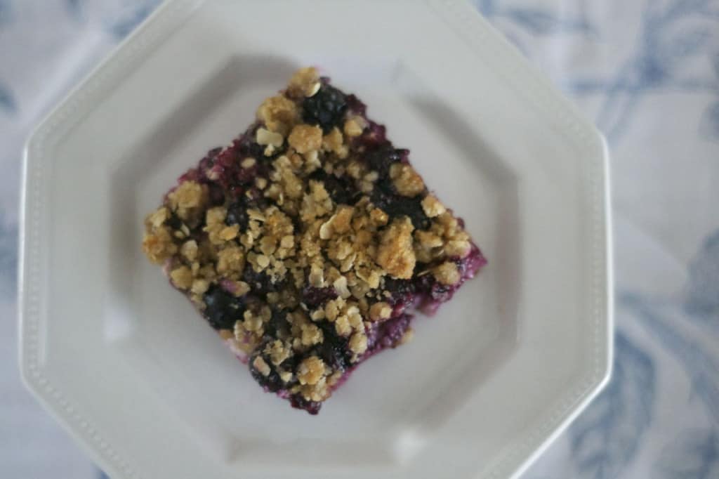 Blueberry Lemon Cheesecake Bars - lemony cheesecake bars covered in blueberries and a lemon streusel topping.