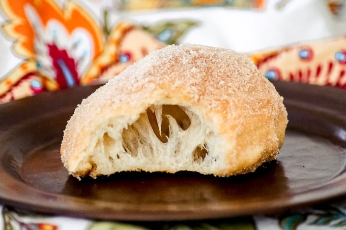 Fried dough aka a doughboy on a plate with a bite taken out.