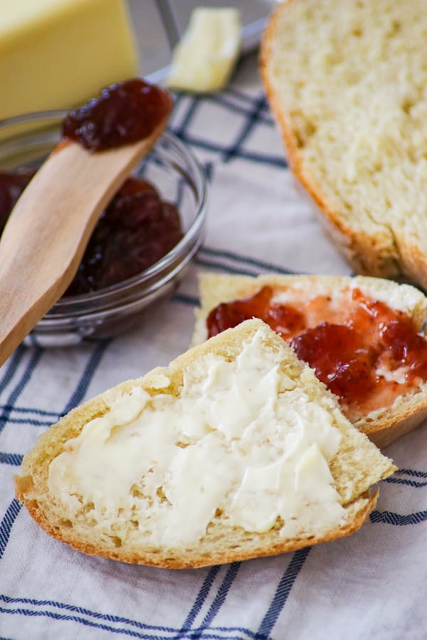 Two slices of Grandma's Italian Bread -one with butter, the other with butter and jam.