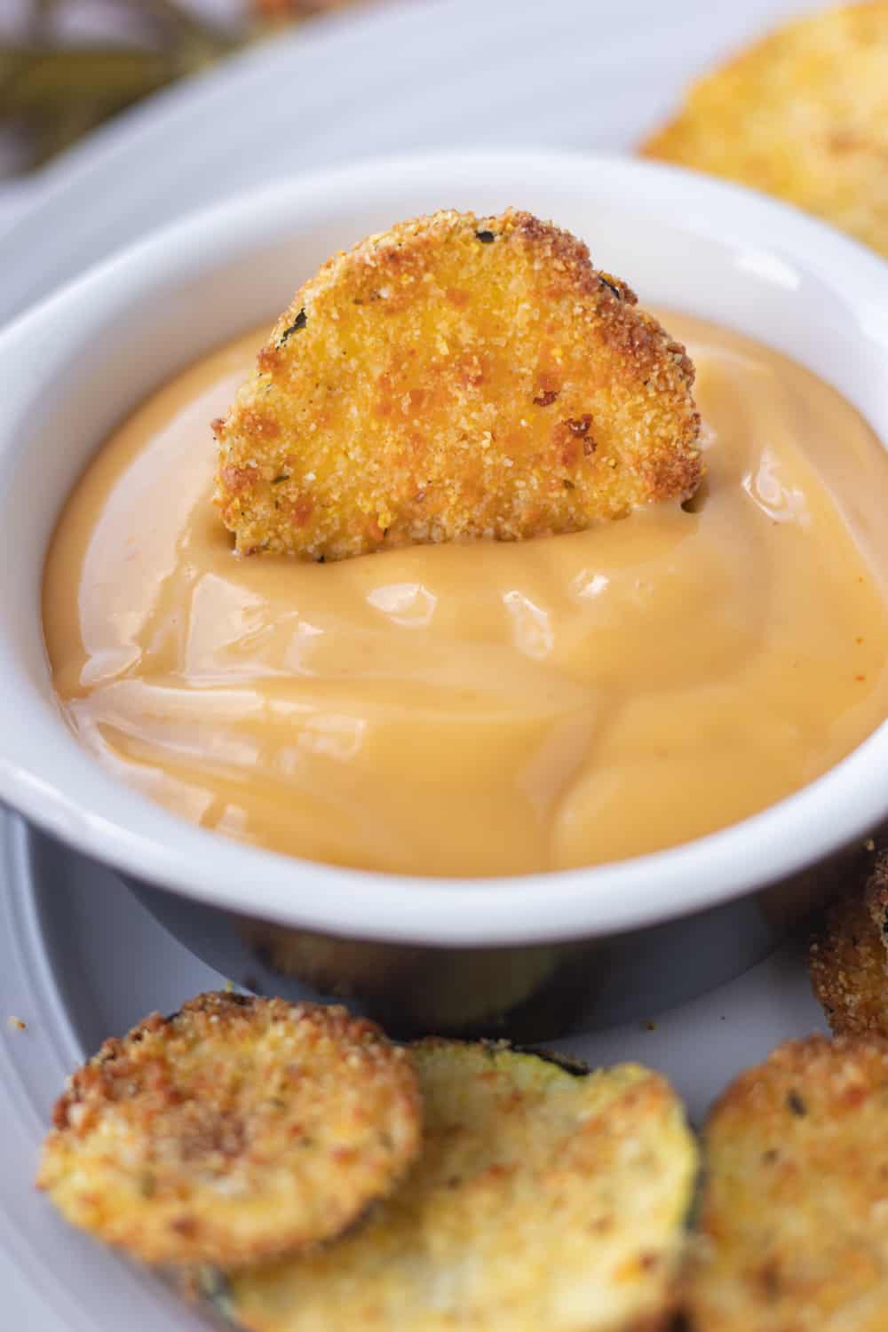 A piece of air fried zucchini in Chick-fil-A sauce.