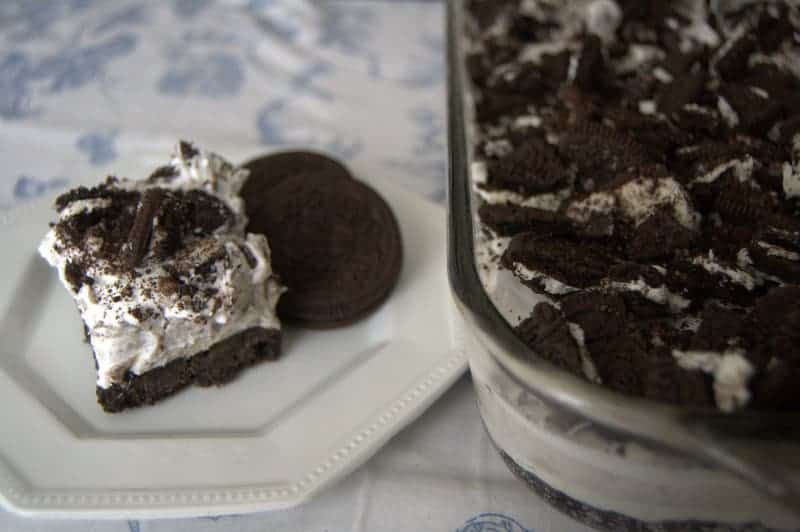 Oreo Cookie Bars - bars made up of an Oreo cookie crust, covered with layers of cream cheese, Cool Whip, Oreo pudding, and crushed Oreo cookies.