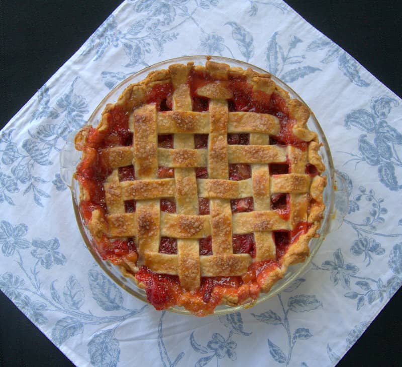 A lattice topped pie filled with a deliciously tart, yet sweet strawberry rhubarb filling accentuated with orange zest .