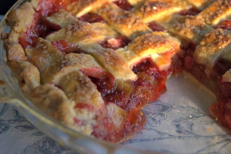 A lattice topped pie filled with a deliciously tart, yet sweet strawberry rhubarb filling accentuated with orange zest .