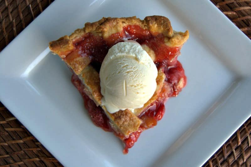 A lattice topped pie filled with a deliciously tart, yet sweet strawberry rhubarb filling accentuated with orange zest .