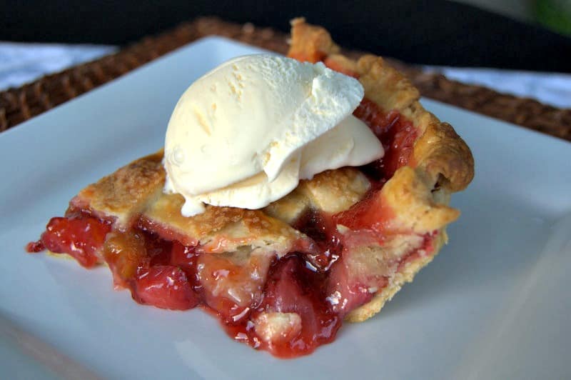 A lattice topped pie filled with a deliciously tart, yet sweet strawberry rhubarb filling accentuated with orange zest .