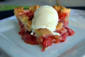 A lattice topped pie filled with a deliciously tart, yet sweet strawberry rhubarb filling accentuated with orange zest .