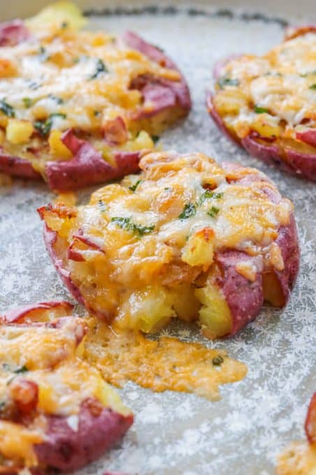Potatoes topped with cheese and chives on a plate.
