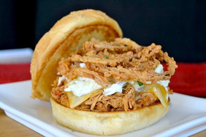 Shredded, slow cooked, barbecue chicken on a Cobblestone Bread Co. Corn Dusted Kaiser Roll topped with melted cheese, cole slaw and onion strings!