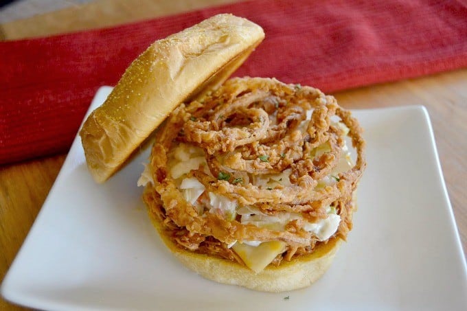 Shredded, slow cooked, barbecue chicken on a Cobblestone Bread Co. Corn Dusted Kaiser Roll topped with melted cheese, cole slaw and onion strings!