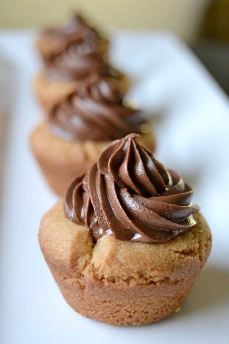 Peanut Butter Cookie Cups stuffed with a mini Reese's and topped with chocolate buttercream!