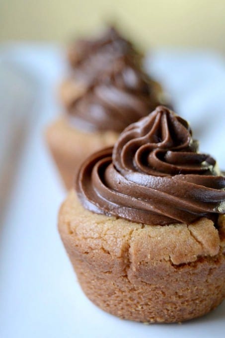 Peanut Butter Cookie Cups stuffed with a mini Reese's and topped with chocolate buttercream!
