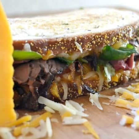 Layers of Wisconsin cheddar and gouda cheeses, caramelized onions, plum chutney and roast beef make up this incredible grilled cheese sandwich!