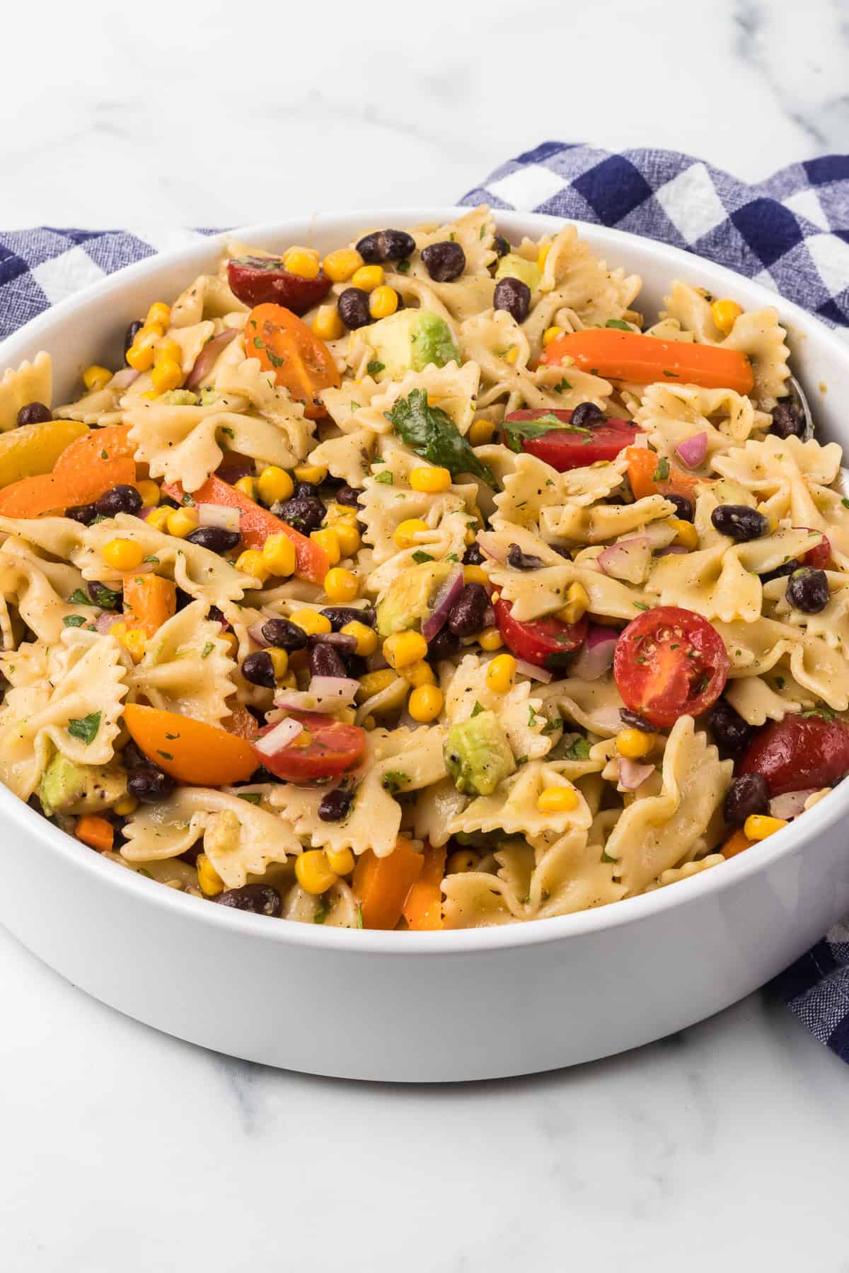 A cold salad with vegetables, black beans and pasta.