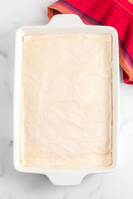 A baking dish filled with spinach, cheese, eggs, olive oil packed in phyllo dough.