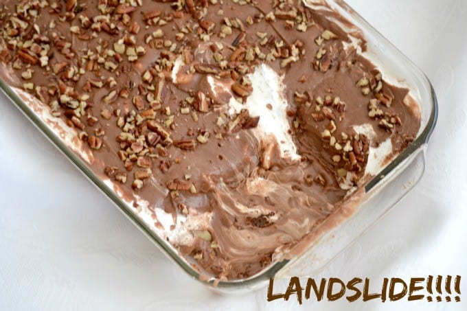 Mississippi Mud Cake is a rich chocolate cake pecans and coconut, topped with a layer of marshmallow cream, chocolate frosting and more pecan pieces.