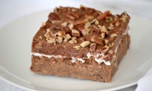 Mississippi Mud Cake is a rich chocolate cake with pecans and coconut, topped with a layer of marshmallow cream, chocolate frosting and more pecan pieces.