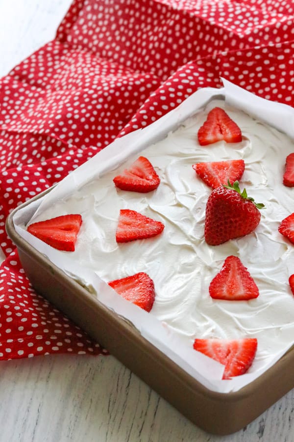 Strawberry Cheesecake Dream Bars - a graham cracker crust, fresh strawberries, a creamy strawberry cheese layer, strawberry creme pudding, topped with whipped topping. These are the perfect dessert to make when strawberries are in season! A pan of Strawberry Cheesecake Dream Bars.