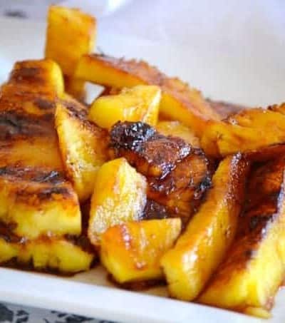 This Grilled Pineapple is soaked in rum, coated in brown sugar and grilled. It's perfect as a simple dessert or as a topping over ice cream.