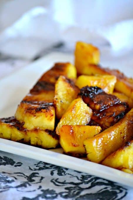 This Grilled Pineapple is soaked in rum, coated in brown sugar and grilled. It's perfect as a simple dessert or as a topping over ice cream.